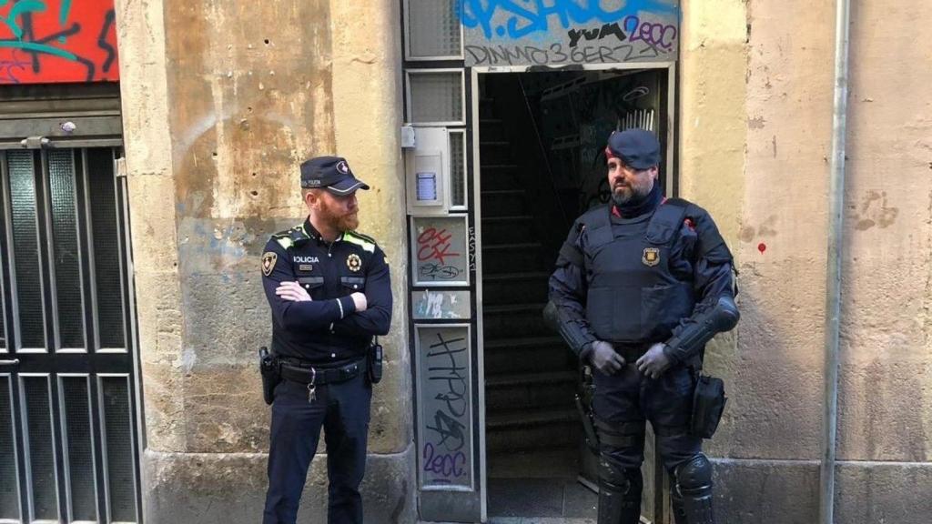 Dos agentes del cuerpo policial delante de una vivienda en Barcelona / EP