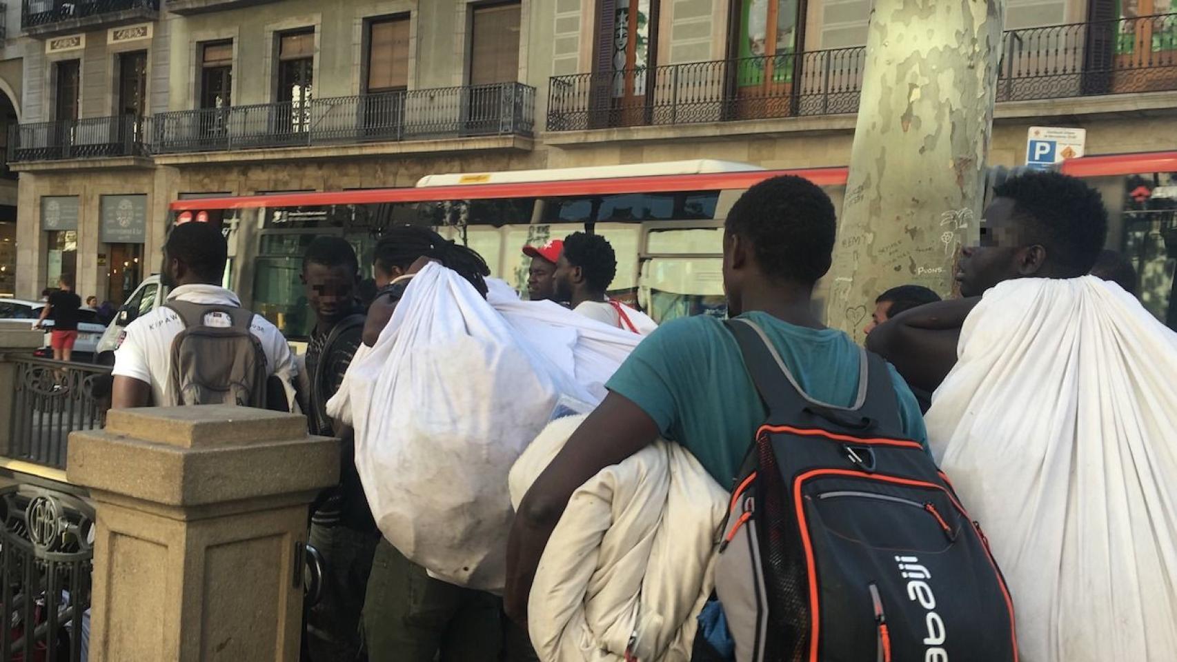 Vendedores ambulantes bajan rápido las escaleras del Metro en La Rambla / P.B.