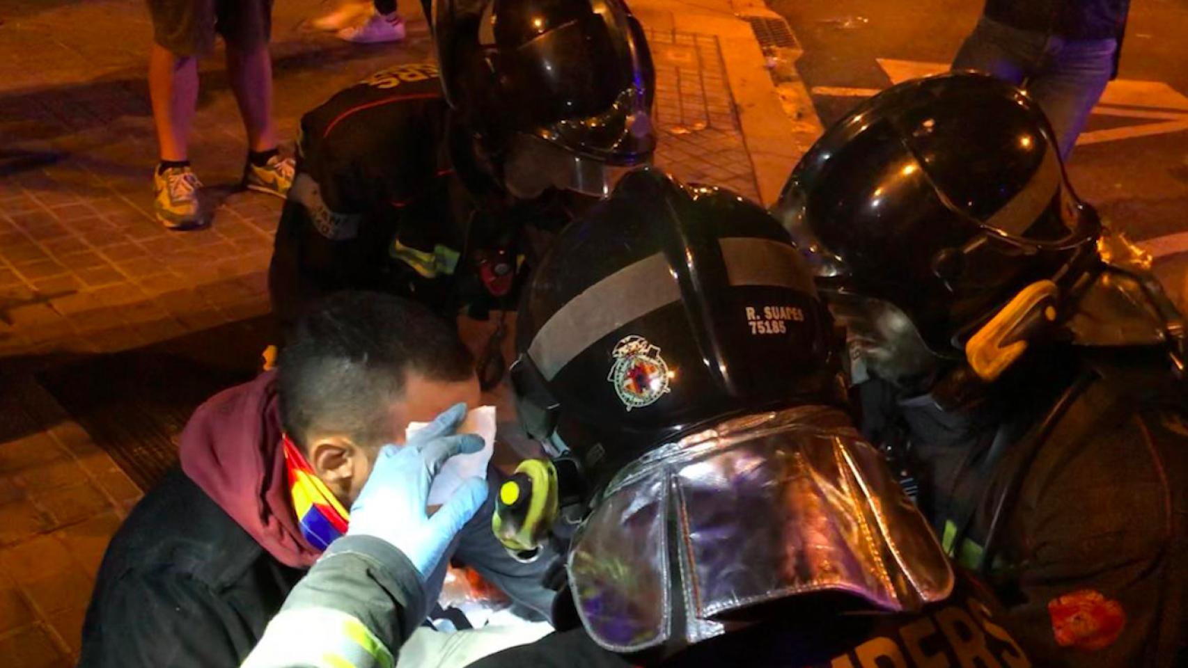 Un joven es atendido por los Bomberos tras ser herido por la policía durante los disturbios en Barcelona / ROGER VILÀ