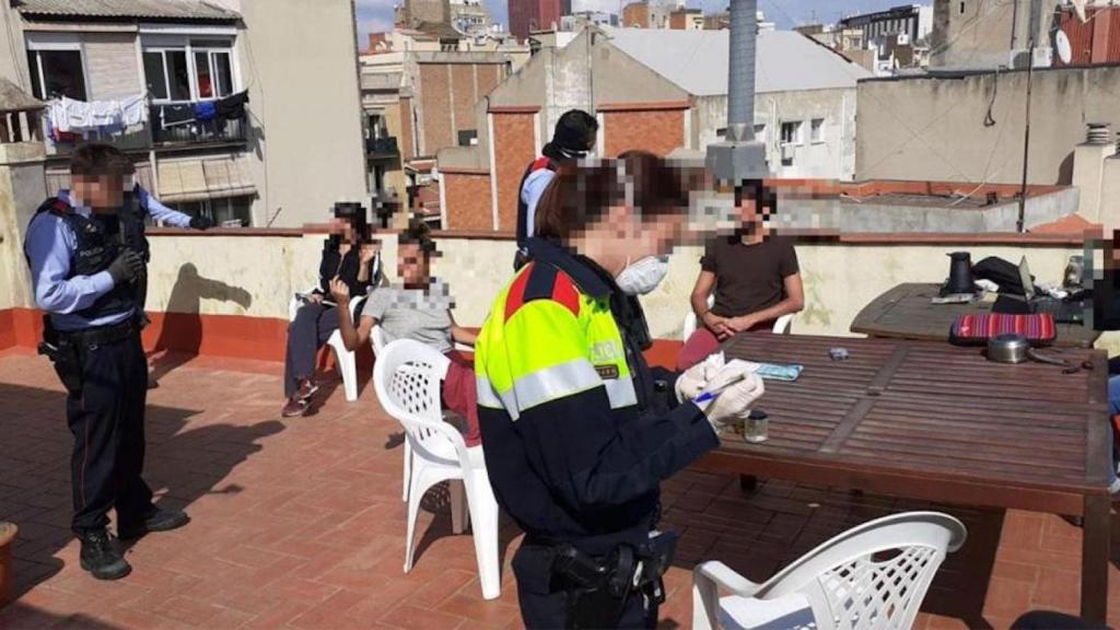 Agentes de los Mossos durante su actuación en la terraza de una casa particular en Sants / CG