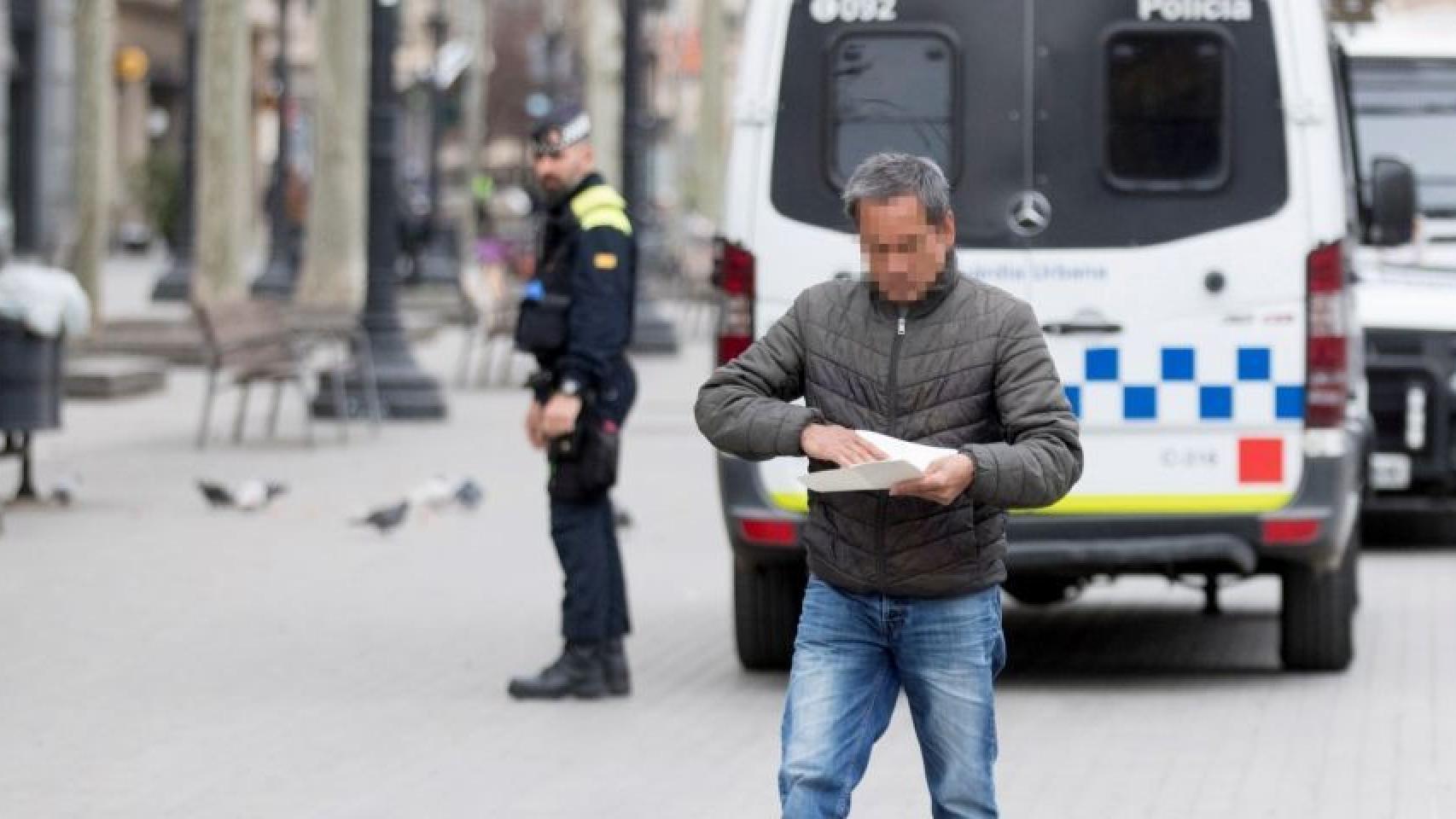 Un ciudadano tras ser multado por la Guardia Urbana de Barcelona / EFE