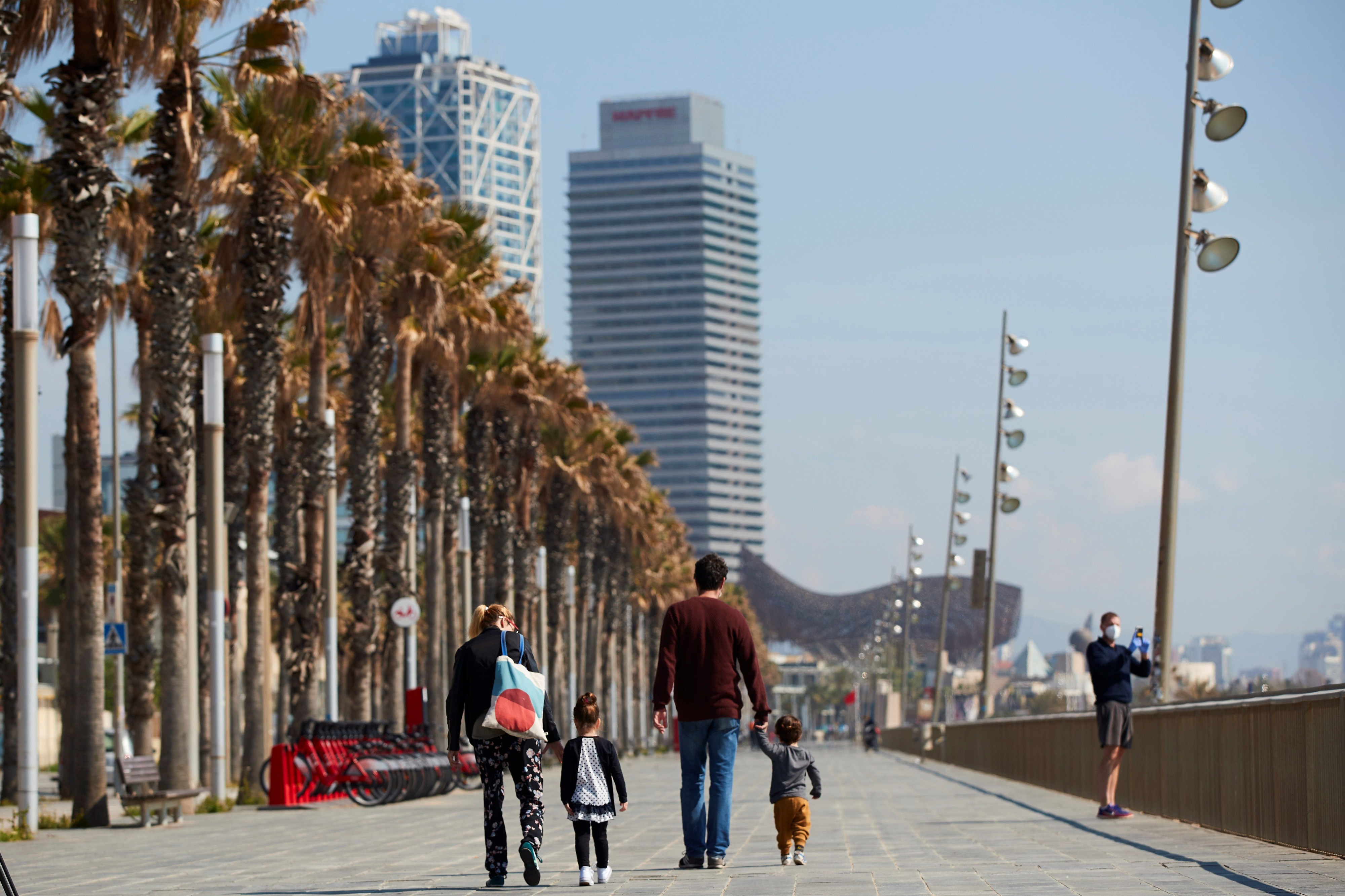 Dos adultos con dos niños en el frente marítimo / EFE