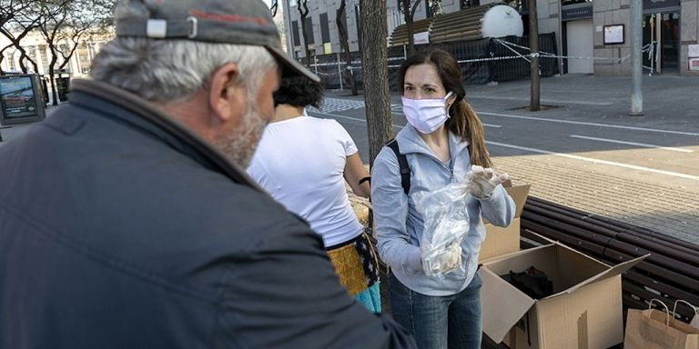 Una voluntaria de Arrels atiende a una persona sintecho / ARRELS FUNDACIÓ