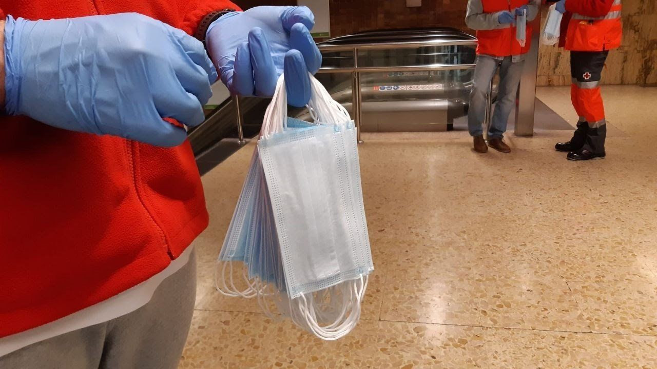 Un voluntario reparte mascarillas en el metro de Barcelona