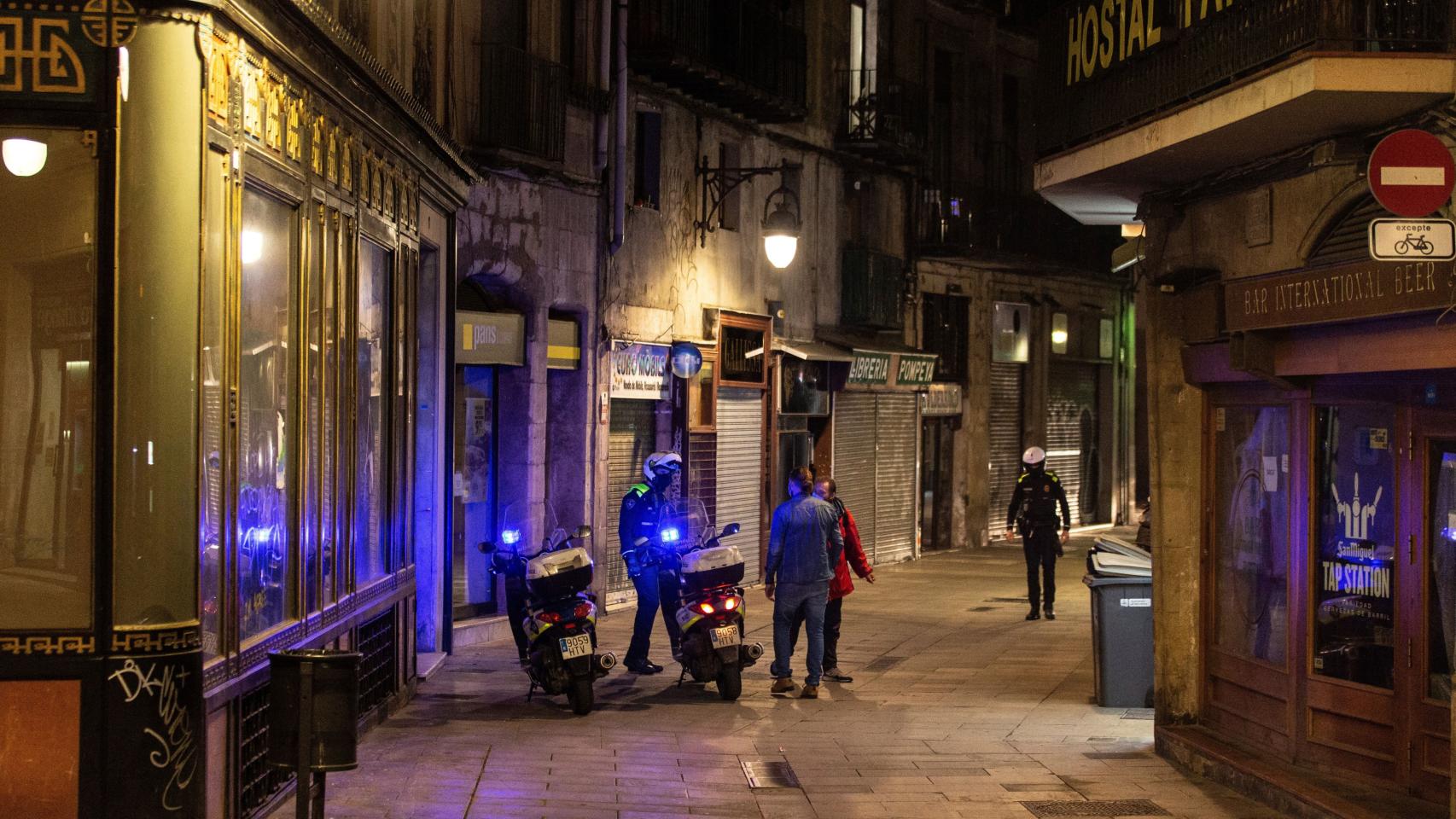 Agentes de la policía hablando con dos personas en el centro de Barcelona / EFE - Enric Fontcuberta