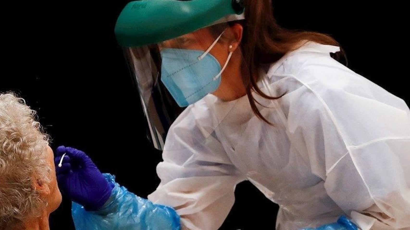 Una profesional de la salud haciendo una prueba PCR a un paciente / EFE