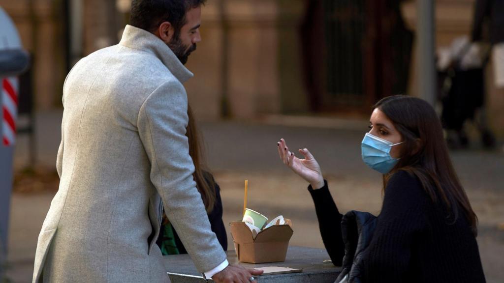 Varias personas almuerzan en un banco de una calle del centro de Barcelona / EFE - Alejandro García