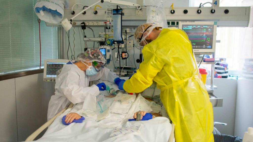 Dos sanitarios atienden a un paciente con coronavirus / HOSPITAL CLÍNIC