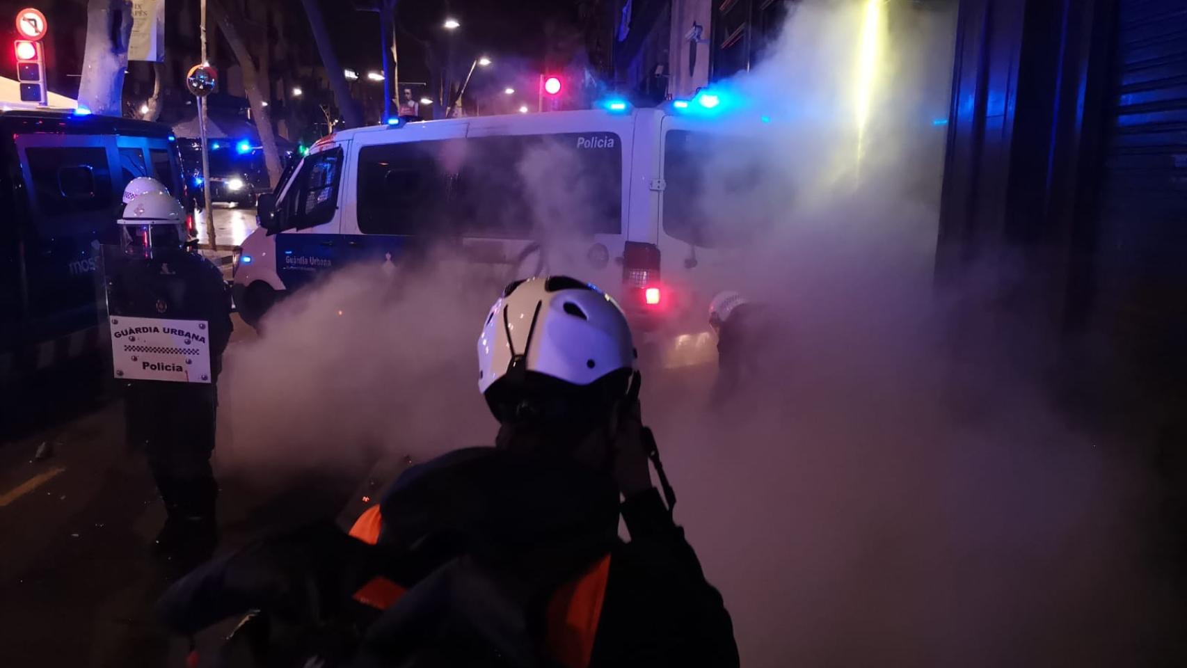 Un agente de la Urbana apaga el incendio en la furgoneta afectada con un extintor / GUILLEM ANDRÉS