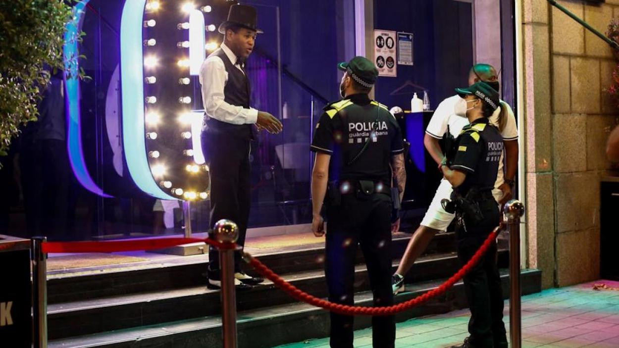 Una patrulla de la Guardia Urbana de Barcelona conversa con un trabajador de un local de ocio nocturno / Quique García / EFE