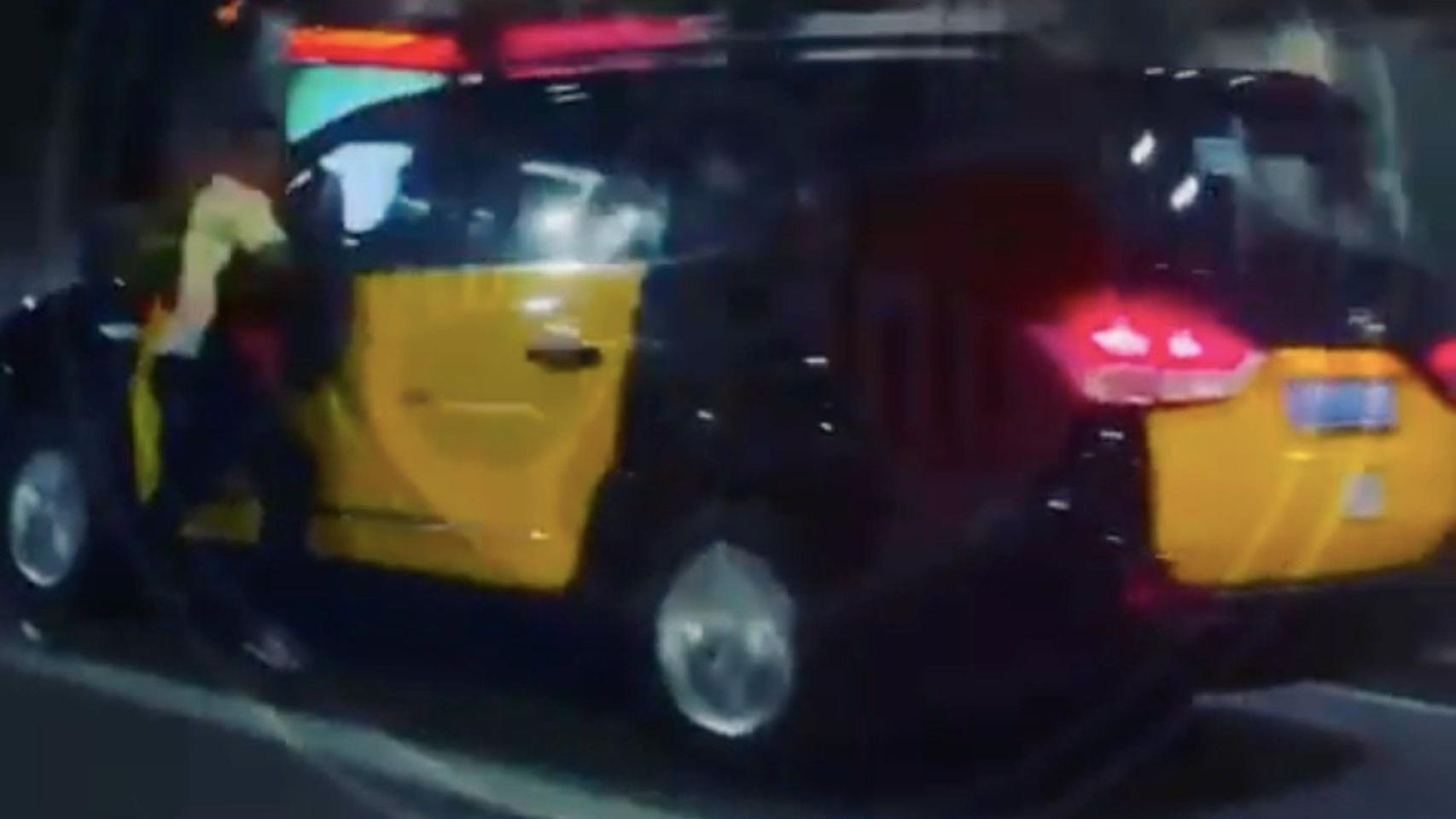 Un hombre se cuelga de un taxi en Barcelona / @POLITEIA.ESP