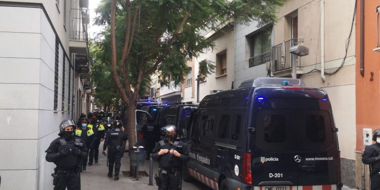 Siete furgones policiales aguardan el desarrollo del desalojo en la calle de Llenguadoc  / GUILLEM ANDRÉS