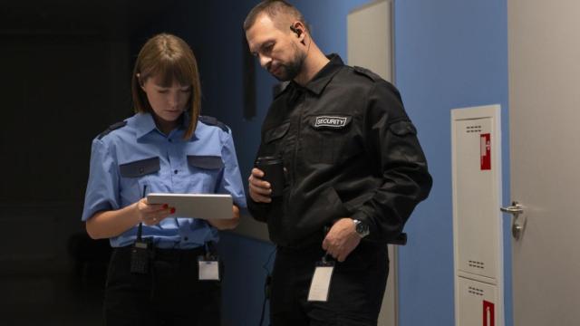 Dos miembros del personal de seguridad de una empresa comprueban datos