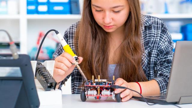 Una joven manipula un robot educativo / FLICKR