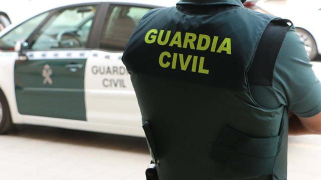 Imagen de archivo de un agente de la Guardia Civil y su coche / REDES
