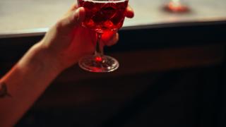 Un hombre sostiene una copa de alcohol