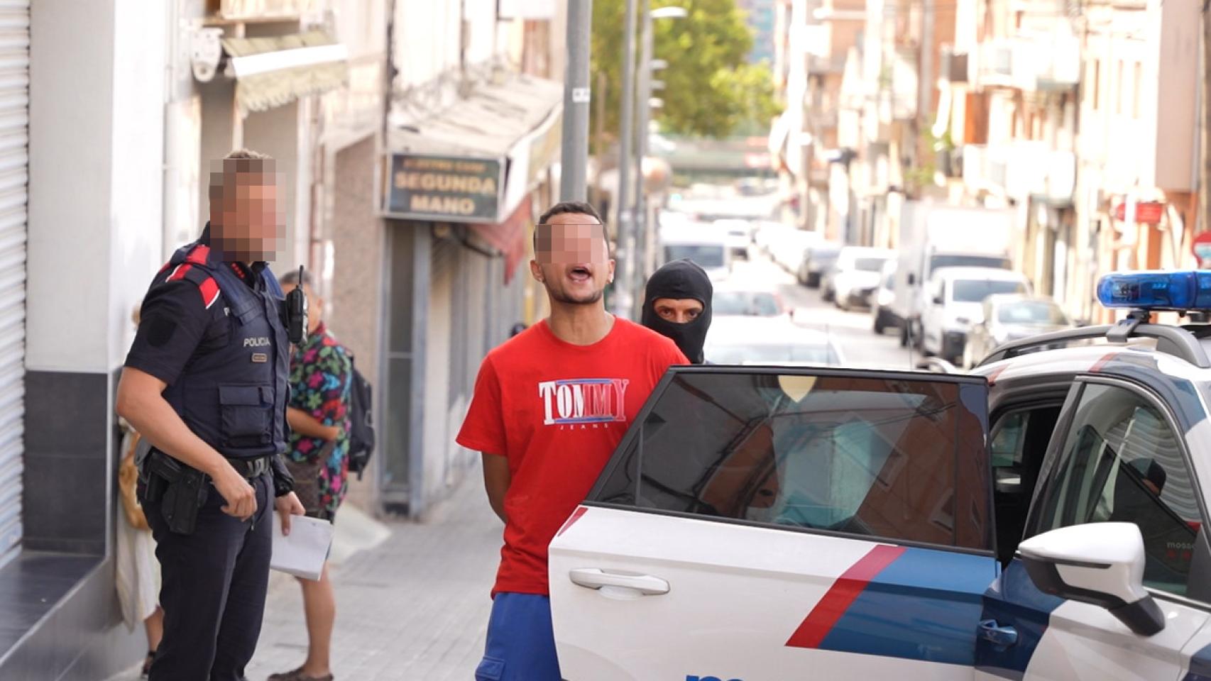 Salida del detenido de uno de los registros efectuados en Badalona