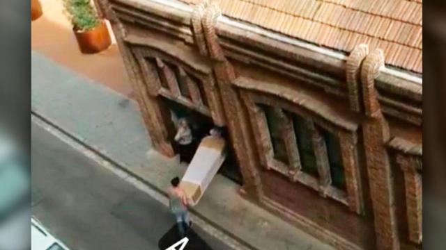 El operador del Tanatorio de Sants, transportando un féretro en mitad de la calle