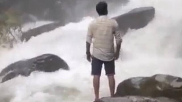 Un hombre a los pies de una catarata