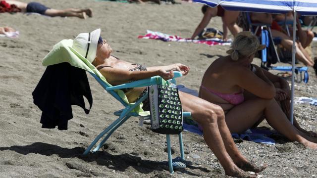 Una mujer tomando el sol en la playa