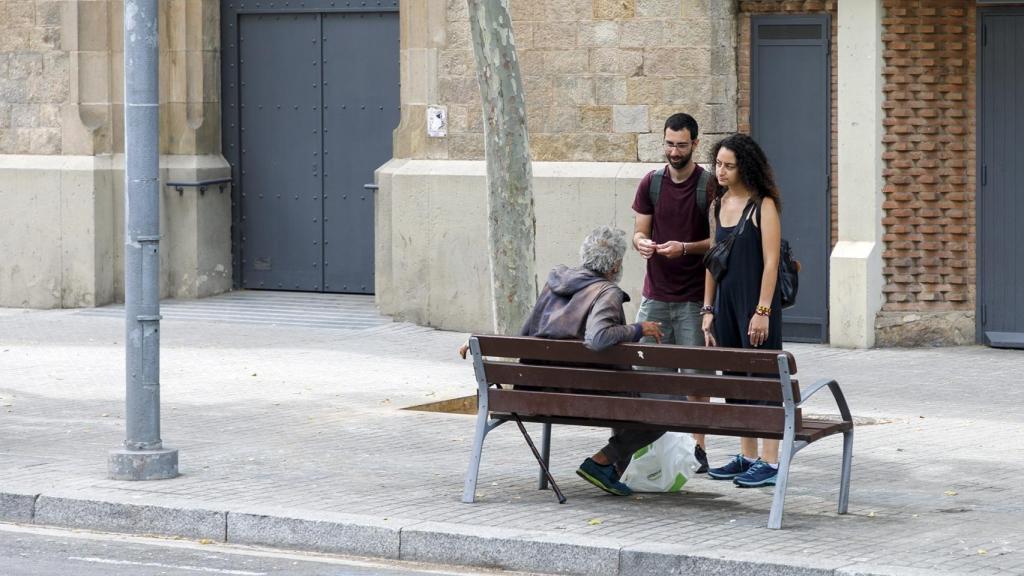 Voluntarios de Arrels con una persona en situación de sinhogarismo en una imagen de archivo