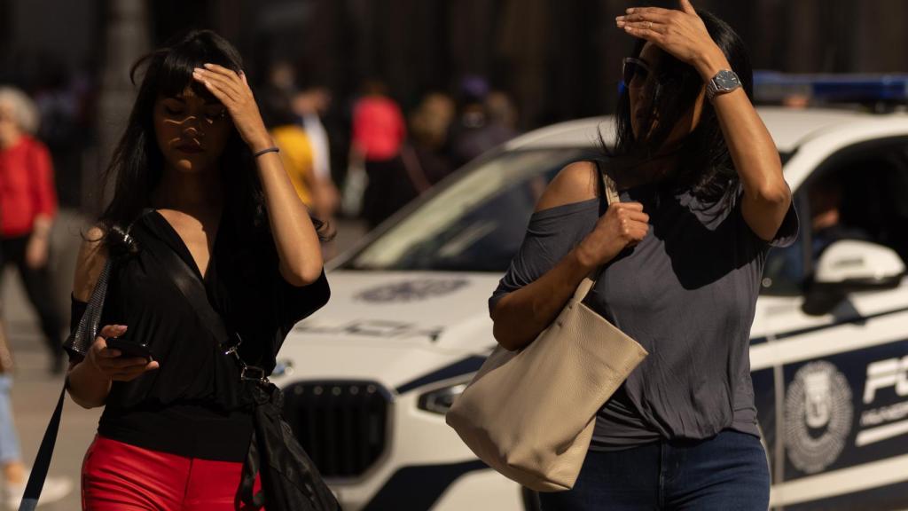 Varias personas usan su mano para taparse del sol