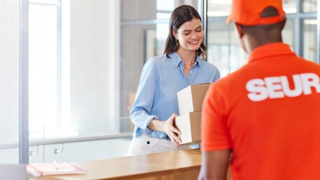 Un repartidor de Seur reparte un paquete