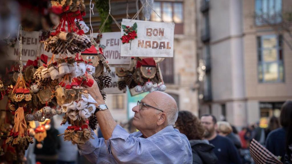 Un hombre mira unos 'tiós' en la Fira de Santa Llúcia