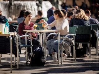 Dos personas hablan en una terraza