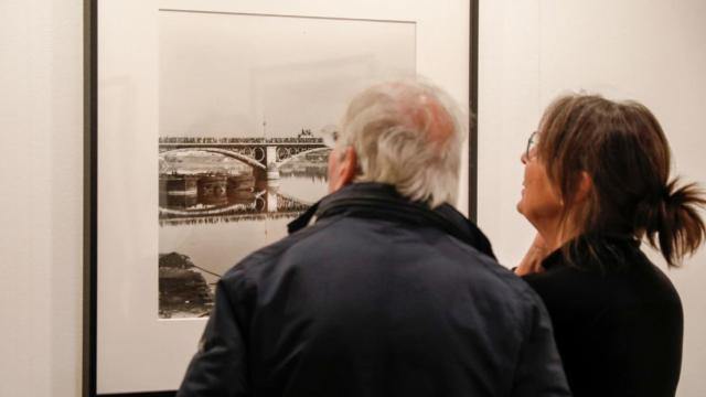 Dos visitantes leen una fotografía en Rastres Compartits
