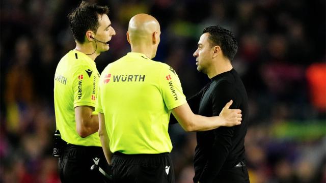 De Burgos Bengoetxea y otro árbitro, hablando con Xavi Hernández