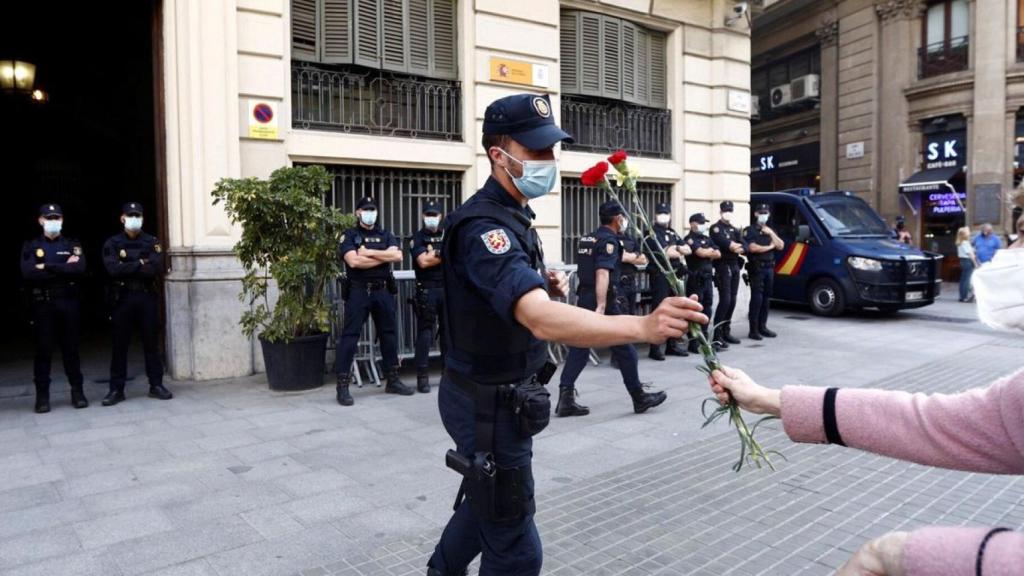 Una ciudadana da un clavel a un agente del CNP ante la Jefatura de Via Laietana