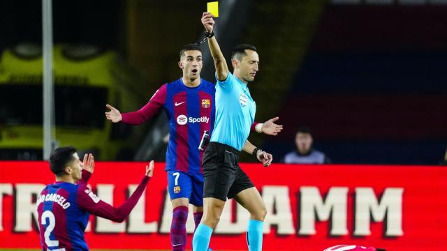 Sánchez Martínez, mostrando una cartulina amarilla a Cancelo durante el Barça-Atlético