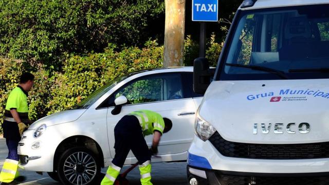 Una grúa municipal retira un vehículo aparcado en una zona reservada para taxis