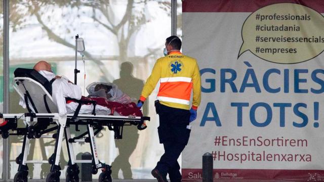 Un sanitario, con un paciente en el Hospital Universitario de Bellvitge de L'Hospitalet
