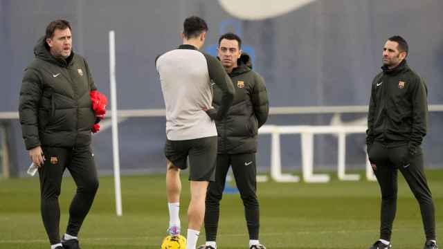 Xavi mantiene una charla con Lewandowski rodeado por miembros de su staff