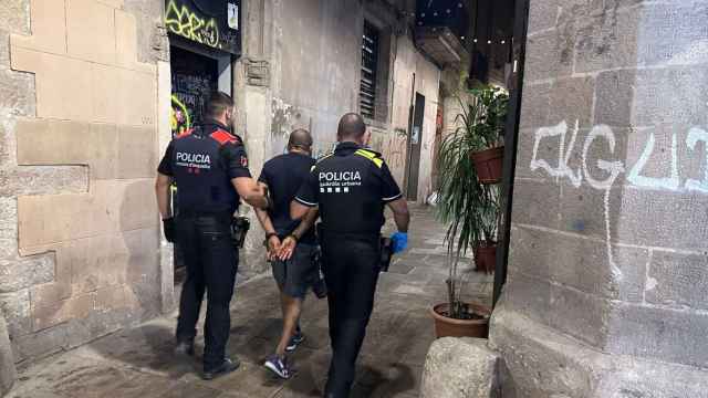 Un agente de Mossos, con uno de la Urbana en una operación contra los narcopisos