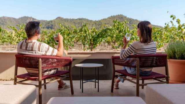 Dos personas se relajan ante viñedos