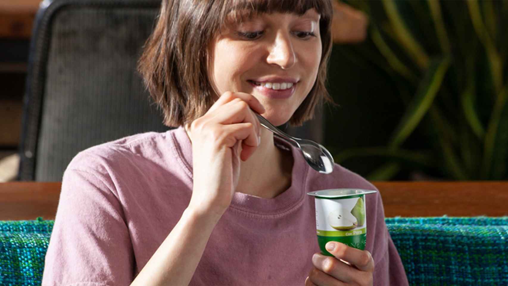 Una joven comiendo un yogur