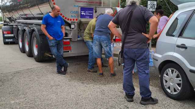 Vecinos de Vallirana llenando sus garrafas de un camión cisterna durante una incidencia con la red de agua