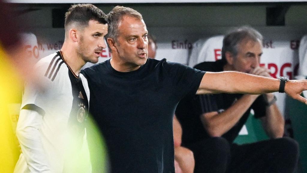 Hansi Flick da instrucciones a un jugador alemán