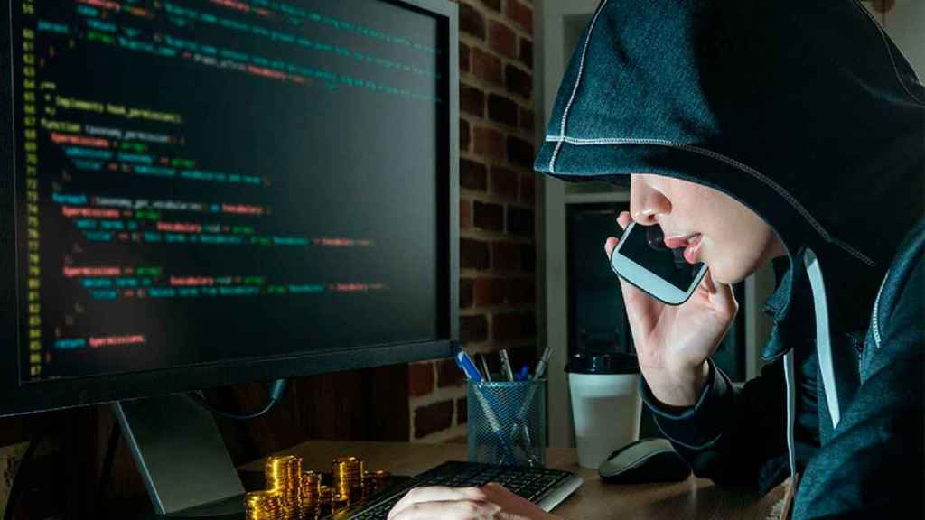 Un ciberdelincuente frente a la pantalla de un ordenador, en un montaje