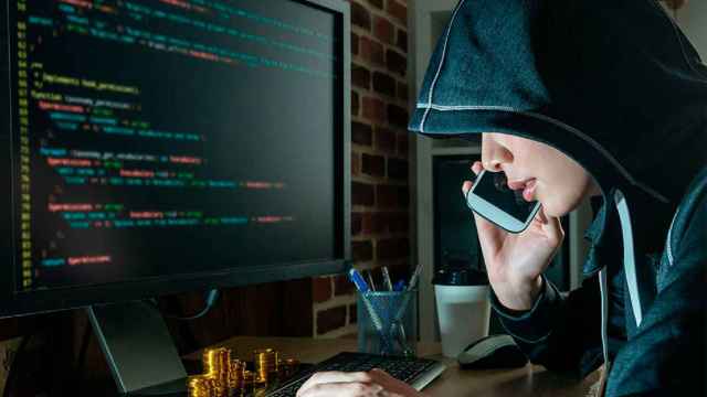 Un ciberdelincuente frente a la pantalla de un ordenador, en un montaje