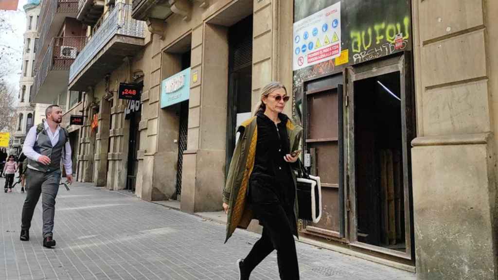 Ciutadans passant davant la promoció de pisos de luxe d'Intermon-Oxfam