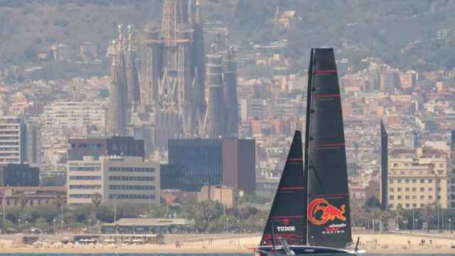 Imagen de un monocasco de la Copa América de vela con la Sagrada Familia de fondo