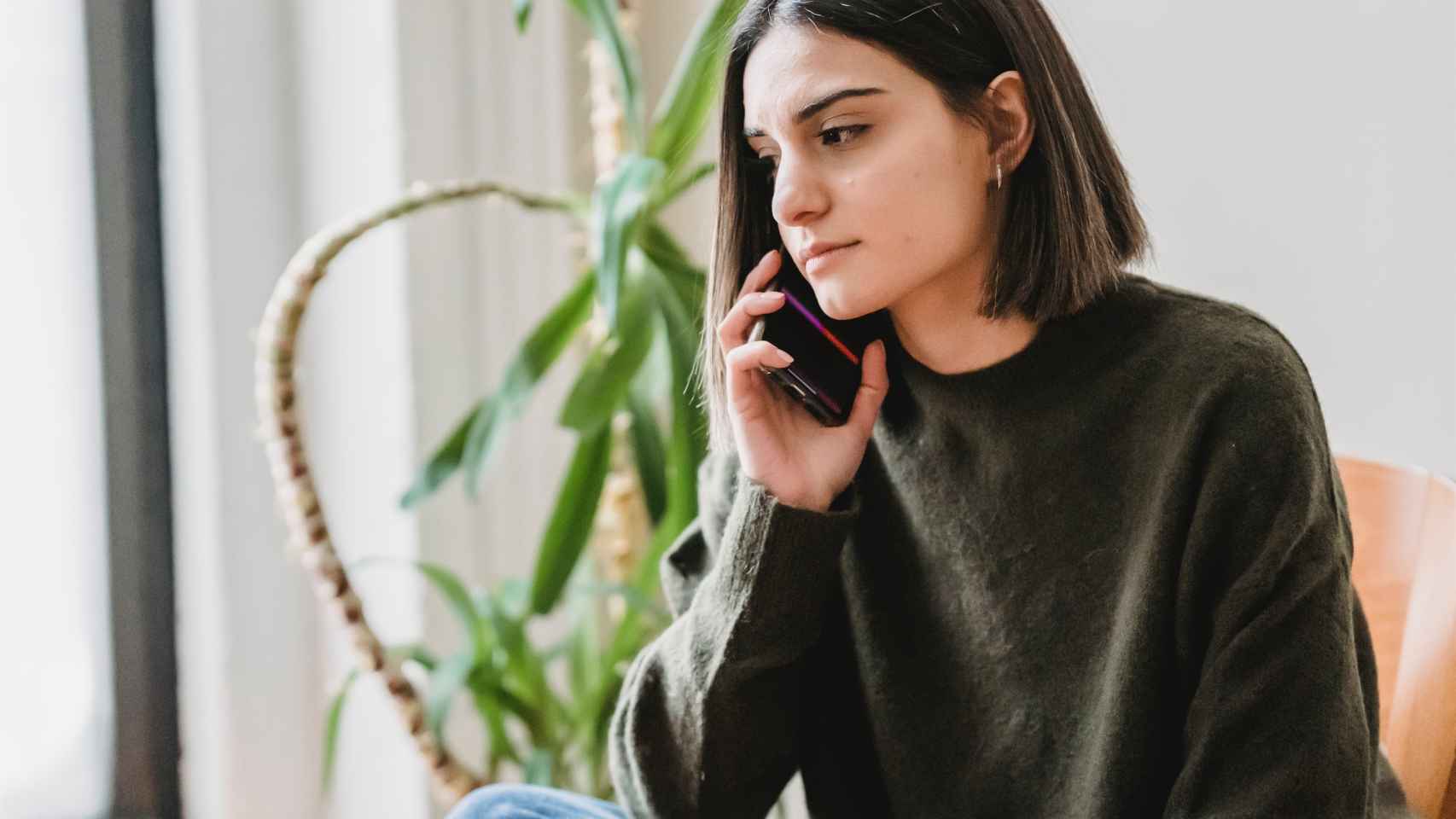 Una mujer joven realiza una llamada telfónica