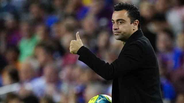 Xavi Hernández hace un gesto con la mano a un jugador del Barça