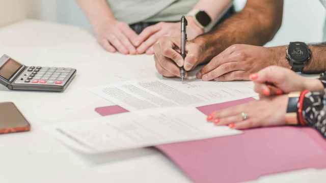 Diversas personas haciendo cálculos en su declaración de la renta