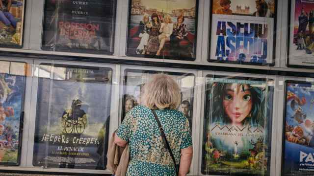 Una persona mayor mira la cartelera de un cine