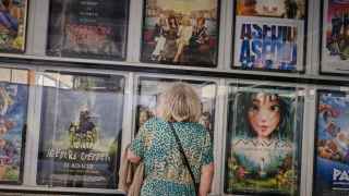 Una persona mayor mira la cartelera de un cine